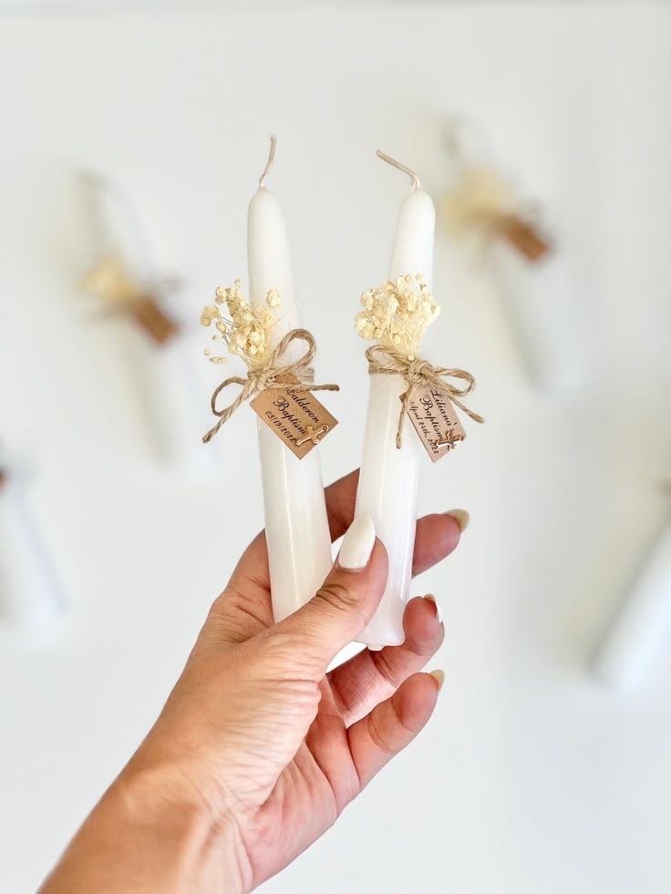 Deux cierges personnalisés avec une corde des fleurs séchée et une étiquette personnalisée