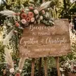 panneau de bienvenue en bois avec écriture maniscrite blanche et pampa